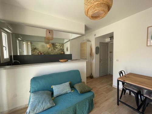 un salon avec un canapé bleu et une table dans l'établissement Studio climatisé avec balcon à 10 mn des plages, à Saint-Raphaël