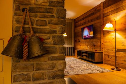 a room with two bells hanging on a stone wall at Haus Freunden in Sankt Anton am Arlberg