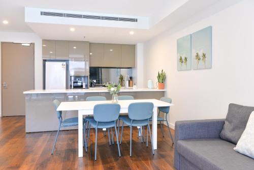a kitchen and living room with a white table and chairs at Sydney CBD Modern 2 bedroom Apartment in Sydney
