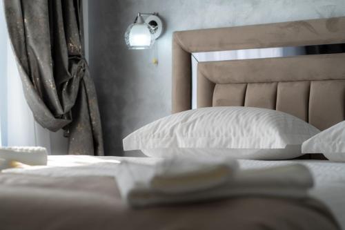 a bedroom with a bed with white pillows at Casa Patry in Călimăneşti