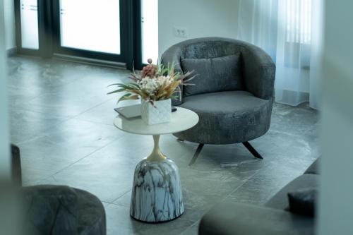 a living room with a chair and a table with flowers at Casa Patry in Călimăneşti