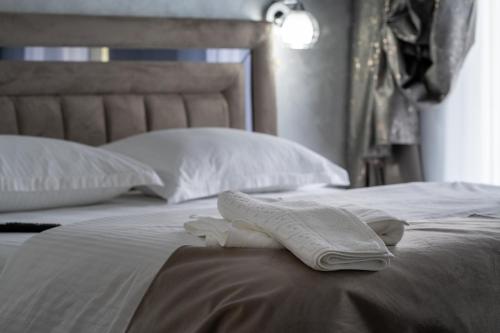 a bed with two white towels sitting on it at Casa Patry in Călimăneşti
