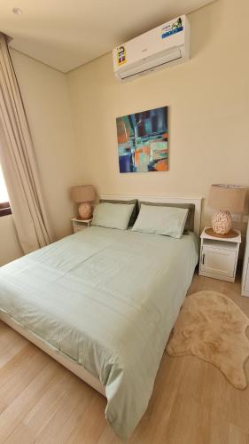 a bedroom with a large white bed with a rug at Darcy's Studio in Salalah