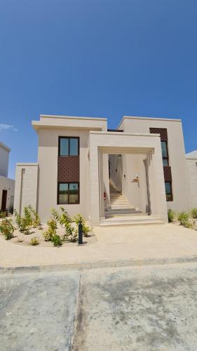 a white house with a fire hydrant in front of it at Darcy's Studio in Salalah