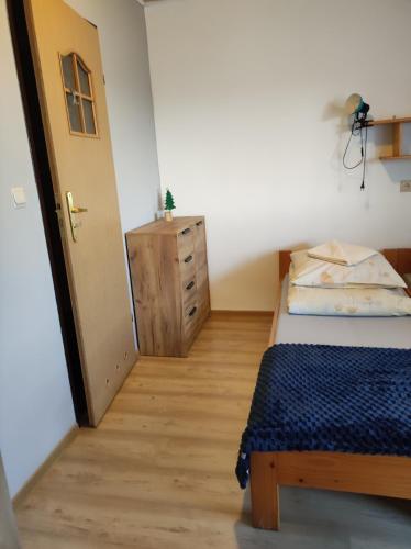a small bedroom with a bed and a dresser at DG EWA w Polańczyku in Polańczyk