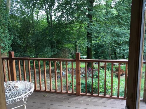 a balcony with a table and a chair on a porch at Woodland Views Lodge in Blandford Forum