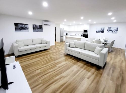 a living room with two white couches and a table at CASA OURO D'ALVA - Luxury Lodging, SPA & WELLNESS in Penalva do Castelo