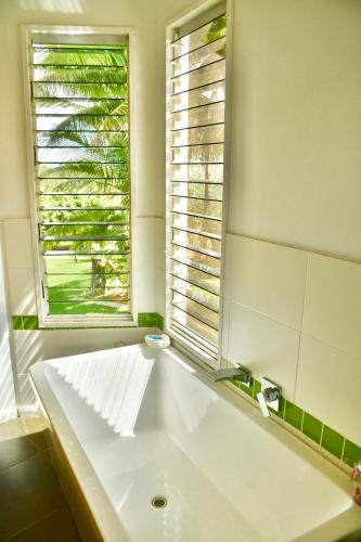 a bathroom with a large white tub and a window at Birds Heaven Mareeba in Mareeba