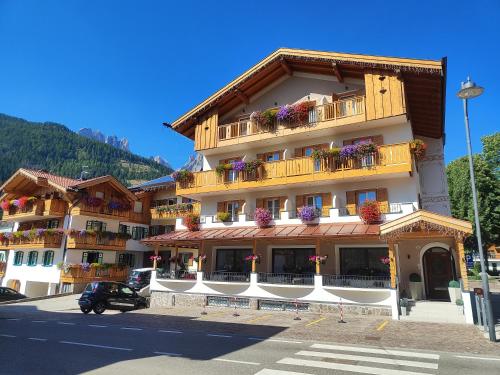 a large building with flower boxes on the balconies at Hotel Villa Cima Undici in Pozza di Fassa