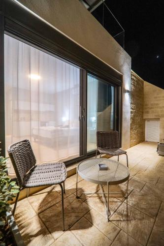 two chairs and a table on a balcony at Amour Relax Hotel in Almirida
