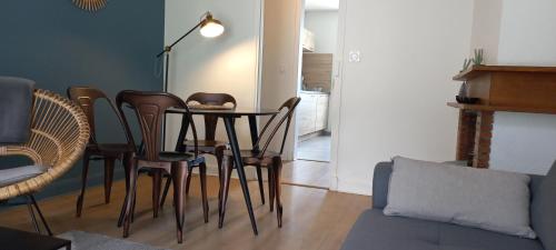 a dining room table and chairs in a living room at Chalet du Doumet - Appart LUZ centre - parking et garage individuel ferme - draps et serviettes inclus in Luz-Saint-Sauveur