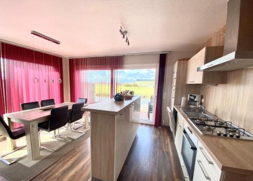 una cucina con un tavolo e una sala da pranzo di Ferienhaus Auszeit direkt am Wasser a Wervershoof