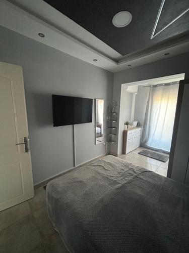 a bedroom with a bed and a flat screen tv at Pefkohori Beautiful Nest free parking 3 adults in Kassandra