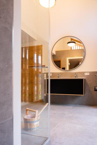 a glass wall in a bathroom with a mirror at Bergblick Chalet in Bayrischzell