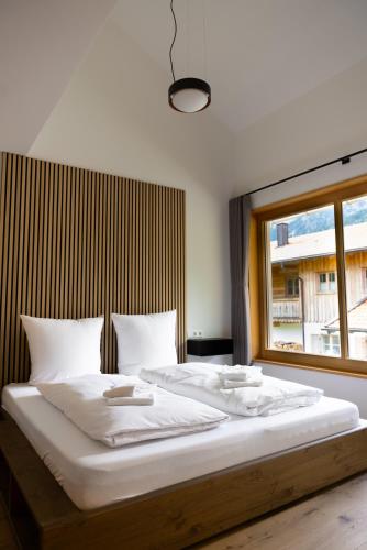 a bedroom with a large white bed with a window at Bergblick Chalet in Bayrischzell