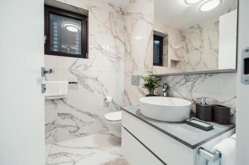 a white bathroom with a sink and a toilet at Villa Kara Sevda in Ražanac