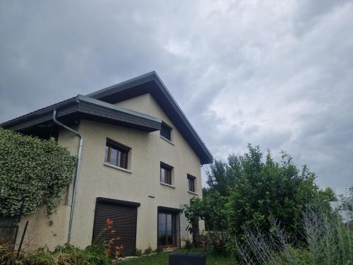 une maison blanche avec un toit noir dessus dans l'établissement Rela, à La Motte-Servolex