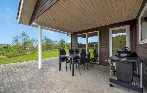 a patio with a table and chairs and a grill at Holiday Home Sydmarken Xi in Falen