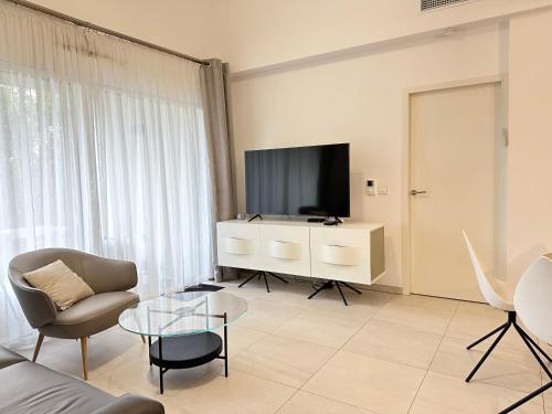 un salon avec une télévision, un canapé et une table dans l'établissement Appartement Palm Beach Proche Croisette, à Cannes