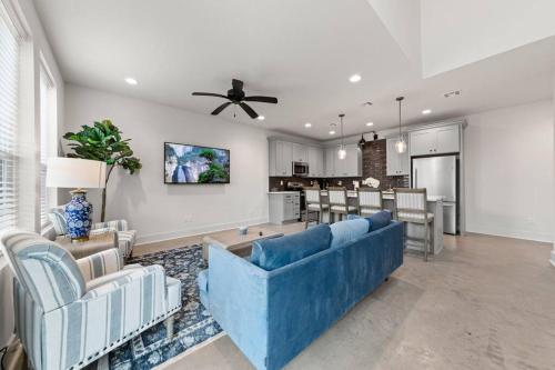 a living room with a blue couch and a kitchen at Cajun French House-2 King Beds-Near Sports Complex in Lafayette