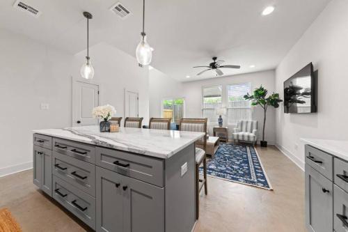 eine Küche mit grauen Schränken und ein Esszimmer in der Unterkunft Cajun French House-2 King Beds-Near Sports Complex in Lafayette