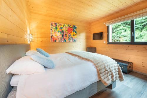a bedroom with a bed in a wooden cabin at Chalet La Souris, chaleureux avec vue panoramique in Gérardmer
