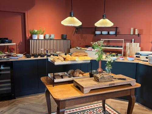a bakery with a table with various types of bread at Südstadt-Hotel Wilhelmshaven in Wilhelmshaven