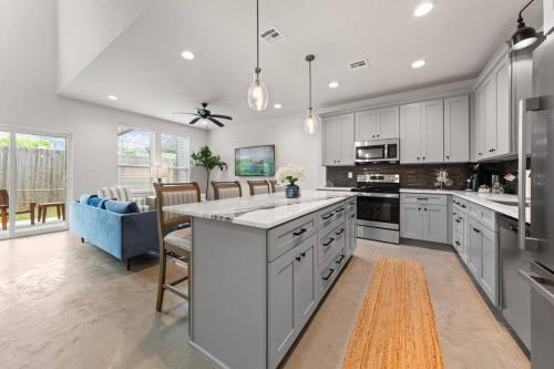 a large kitchen with white cabinets and a blue couch at Cajun French House-2 King Beds-Near Sports Complex in Lafayette