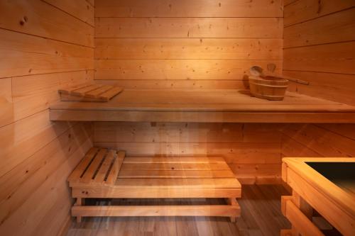 un sauna en bois avec un banc à l'intérieur dans l'établissement Chalet La Souris, chaleureux avec vue panoramique, à Gérardmer