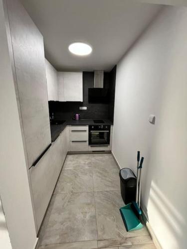 a small kitchen with white cabinets and a tile floor at Útulný nový byt 1 km od Kristýny in Hrádek nad Nisou