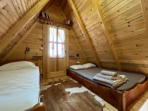 a room with two beds in a log cabin at Kućica naša bajka in Kupinovo
