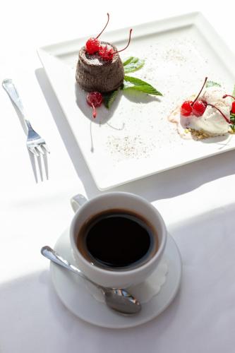 a cup of coffee and a piece of dessert on a plate at Pušynė in Birštonas