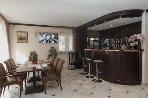 a dining room with a table and a bar at Pušynė in Birštonas