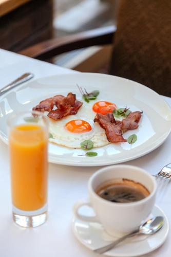 a plate of eggs and bacon next to a cup of coffee at Pušynė in Birštonas