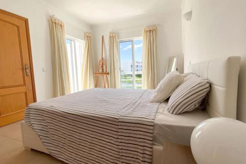 Un dormitorio blanco con una cama grande y una ventana. en Galé Premium House - Pet Friendly, en Albufeira