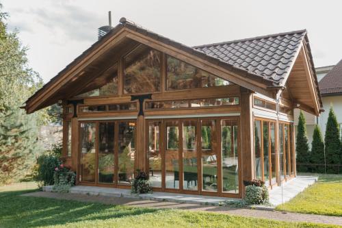 a glass house with a gambrel roof at Pušynė in Birštonas