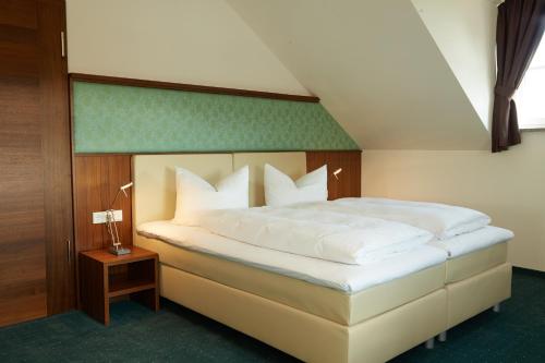 um quarto com uma cama grande e almofadas brancas em Pfaffinger Hof em Pfaffing