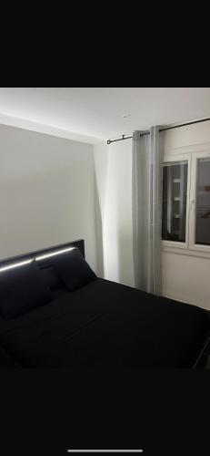 une chambre avec un lit noir et une fenêtre dans l'établissement Maison de vacances, à Tourbes