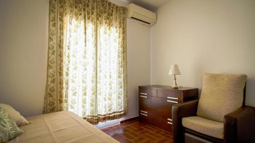 a bedroom with a bed and a chair and a window at Pego CC in Pego