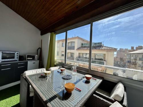 - une table sur un balcon avec vue sur un bâtiment dans l'établissement Studio Mezzanine Lumineux à 50m de la Plage – 5 Couchages à Sainte-Maxime - FR-1-226-474, à Sainte-Maxime