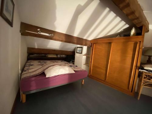 - une petite chambre avec un lit et une armoire en bois dans l'établissement Studio Mezzanine Lumineux à 50m de la Plage – 5 Couchages à Sainte-Maxime - FR-1-226-474, à Sainte-Maxime