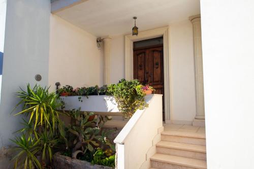 a stairway with potted plants and a door at Bed e breakfast Terra e Mare in Sava