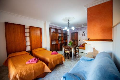 a room with two beds and a couch and a table at Bed e breakfast Terra e Mare in Sava