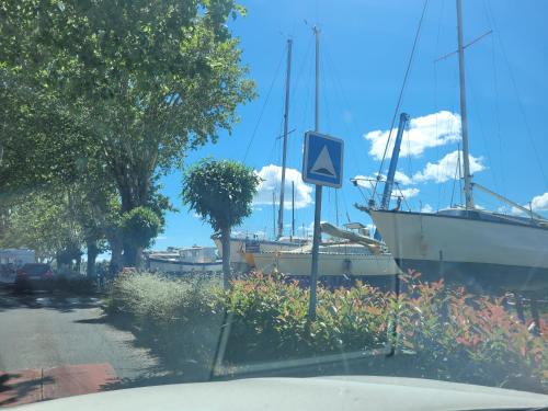 un bateau garé à côté d'une rue avec un panneau dans l'établissement Agde centre historique location de samedi à samedi, à Agde