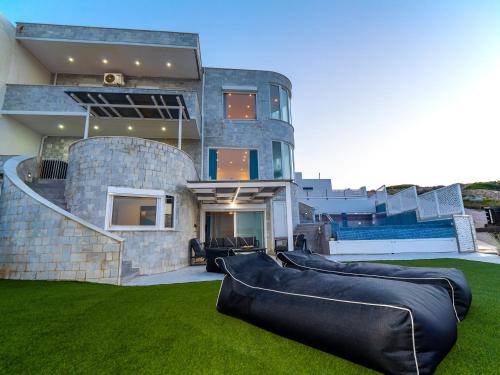 a house with three large pillows on the lawn at En plo villa Sounio in Sounio