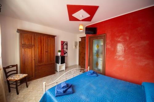 a bedroom with a bed and a red wall at Bed e breakfast Terra e Mare in Sava