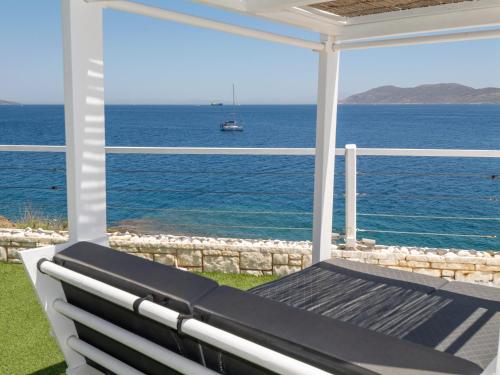 a porch with a bench looking out at the ocean at En plo villa Sounio in Sounio