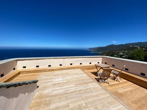 a balcony with two chairs and a view of the ocean at Torra di Ciocce in Pino