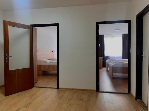 a room with two mirrors and a bedroom with a bed at Hotel Akadémia in Košice