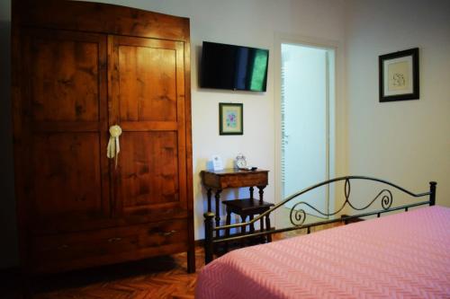 a bedroom with a bed and a dresser and a tv at Agriturismo Il Colle Del Contadino in Castelraimondo